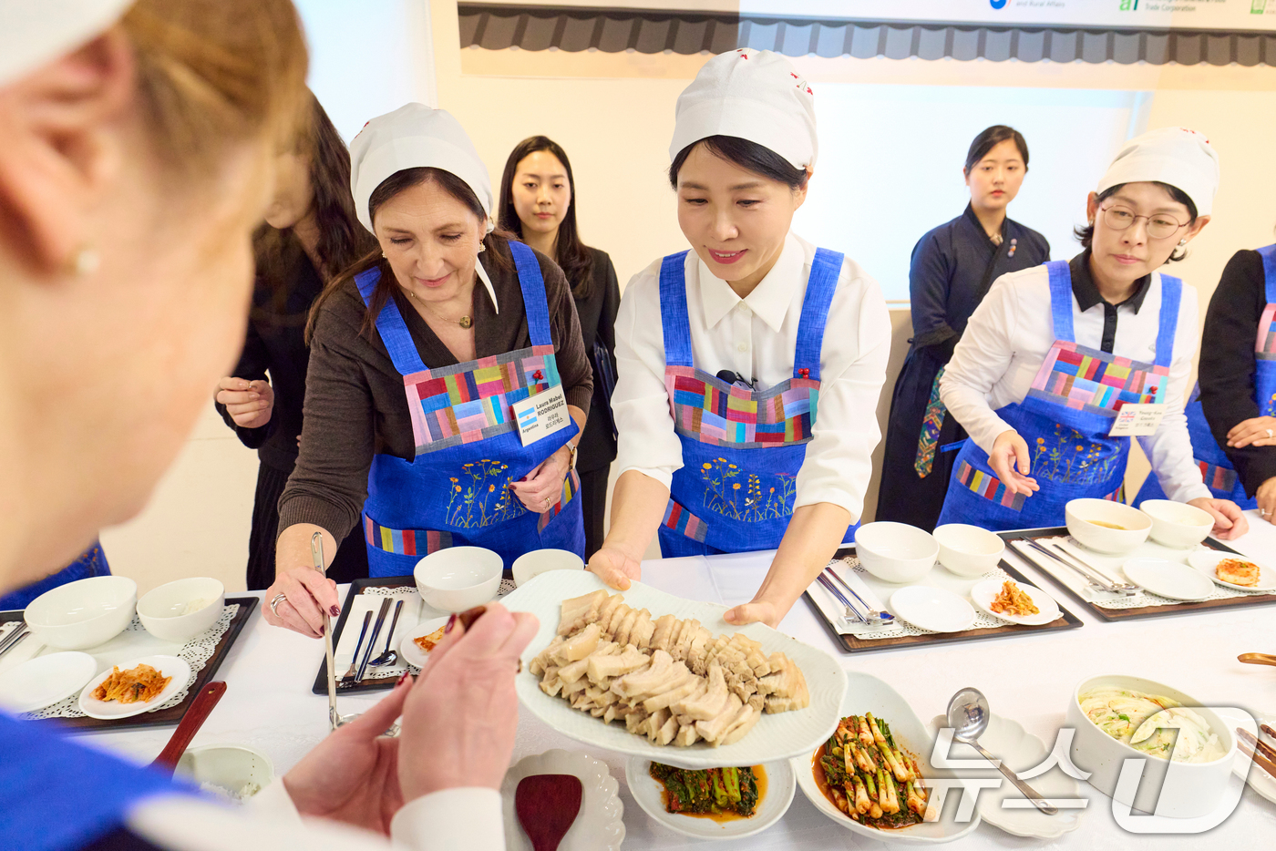 (서울=뉴스1) 허경 기자 = 김혜경 여사가 9일 서울 종로구 북촌 한식문화공간 이음에서 열린 주한대사 배우자 초청 김장 행사에서 참석자들에게 보쌈을 나눠주고 있다. (대통령실 제 …