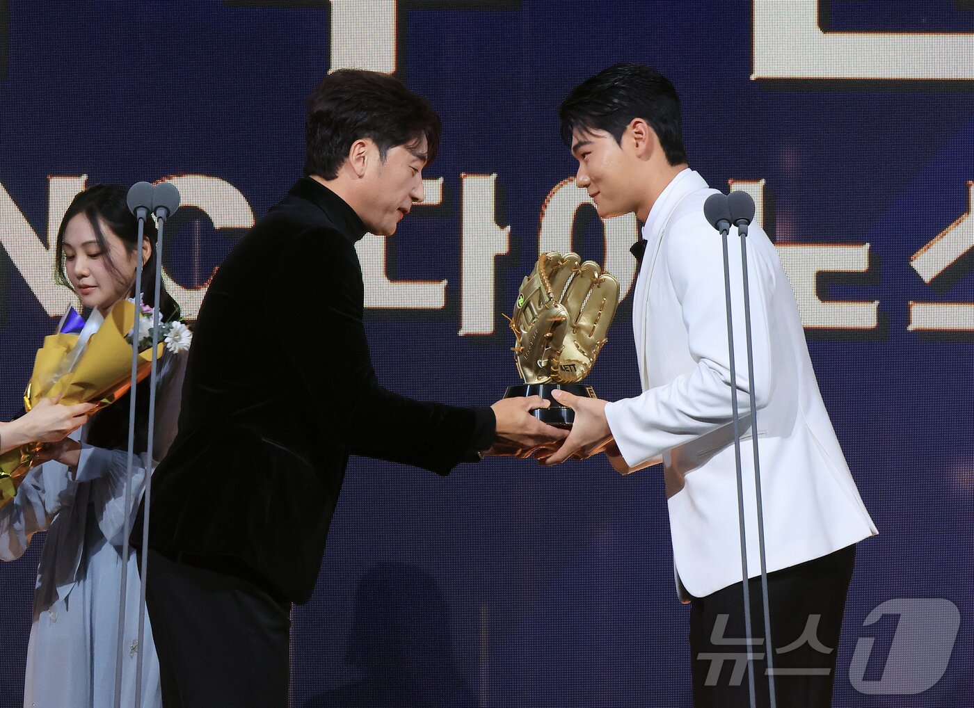 본문 이미지 - 9일 오후 서울 송파구 롯데호텔 월드에서 열린 프로야구 2025 신한 SOL뱅크 골든글러브 시상식에서 유격수 부문 골든글러브를 수상한 NC 김주원이 이택근 해설위원에게 트로피를 받고 있다. 2025.12.9 ⓒ 뉴스1 김진환 기자