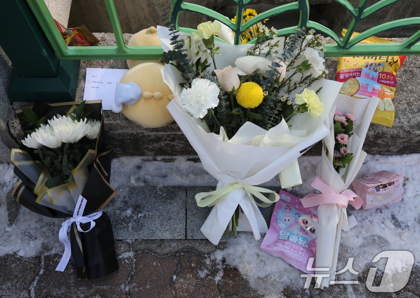 본문 이미지 - 지난 10일 대전 서구 한 초등학교에서 1학년 A양이 교사에 의해 흉기에 찔려 사망하는 사고가 발생했다. 11일 범행이 발생한 학교입구에 A양을 추모하는 국화꽃과 메모가 놓여 있다. 2025.2.11/뉴스1 ⓒ News1 김기태 기자