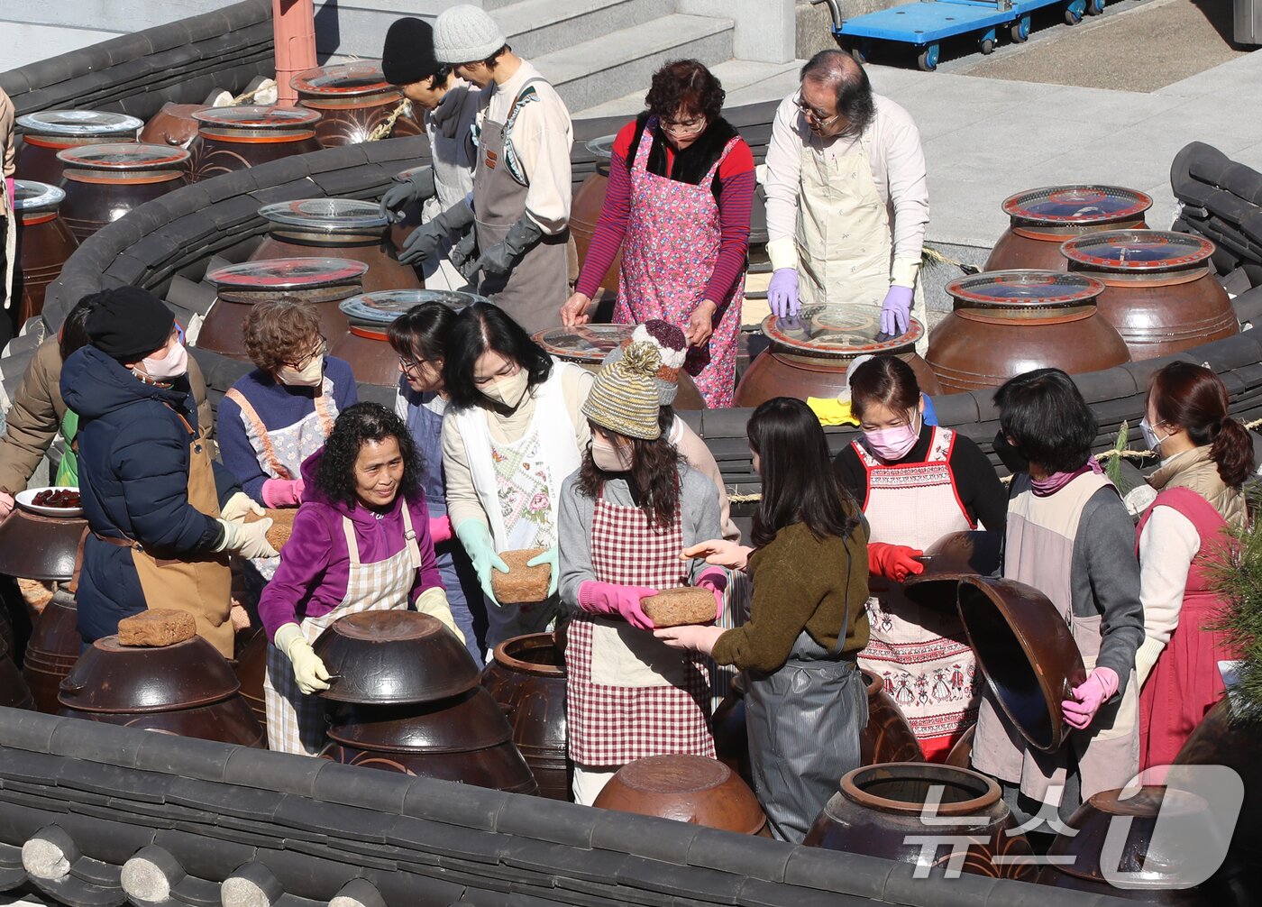 본문 이미지 - 11일 부산 기장군농업기술센터에서 '한국형 식문화실천교육 전통장류과정' 수강생들이 장독대를 활용한 전통 장을 담그고 있다. 잊혀져 가는 우리 전통 장맛을 계승하고 건강한 식문화 실천을 위해 마련된 이번 교육은 5회에 걸쳐 전통 된장과 간장, 고추장, 막장 만들기가 진행된다. 2025.2.11 ⓒ 뉴스1 윤일지 기자