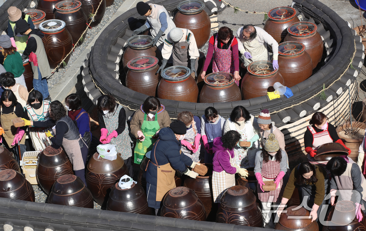 (부산=뉴스1) 윤일지 기자 = 11일 부산 기장군농업기술센터에서 '한국형 식문화실천교육 전통장류과정' 수강생들이 장독대를 활용한 전통 장을 담그고 있다.잊혀져 가는 우리 전통 장 …