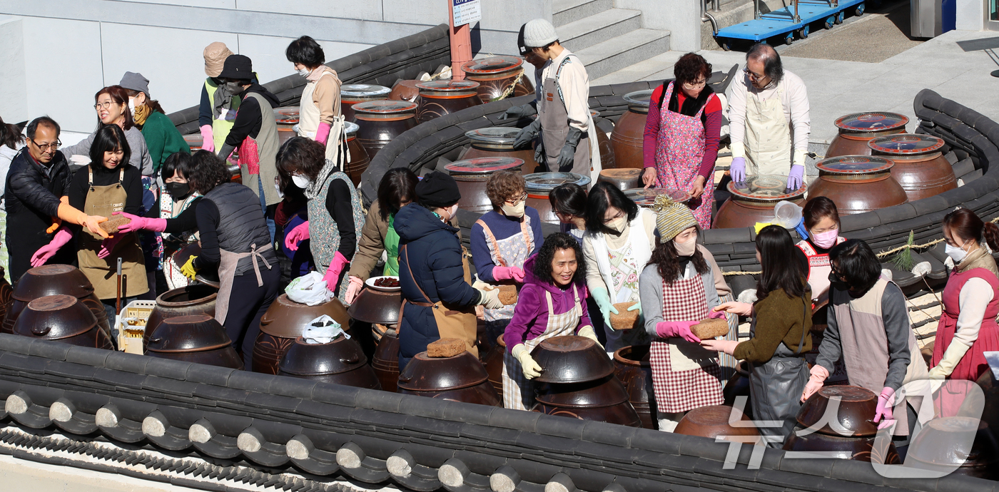 (부산=뉴스1) 윤일지 기자 = 11일 부산 기장군농업기술센터에서 '한국형 식문화실천교육 전통장류과정' 수강생들이 장독대를 활용한 전통 장을 담그고 있다.잊혀져 가는 우리 전통 장 …