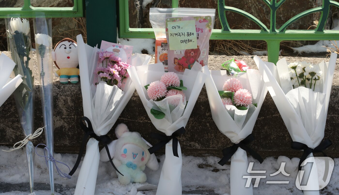 본문 이미지 - 지난 10일 대전 서구 한 초등학교에서 1학년 A양이 교사에 의해 흉기에 찔려 사망하는 사고가 발생했다. 11일 범행이 발생한 학교입구에 A양을 추모하는 국화꽃과 메모가 놓여 있다. 2025.2.11/뉴스1 ⓒ News1 김기태 기자