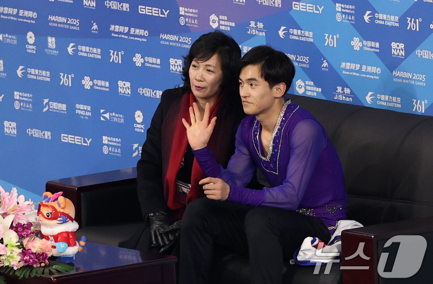 본문 이미지 - 북한 피겨 로영명이 11일&#40;현지시간&#41; 중국 헤이룽장성 하얼빈 빙상훈련센터 다목적홀에서 열린 하얼빈 동계아시안게임 피겨 남자 싱글 쇼트에서 연기를 마치고 점수 확인을 위해 대기하며 손인사하고 있다. 2025.2.11/뉴스1 ⓒ News1 이승배 기자