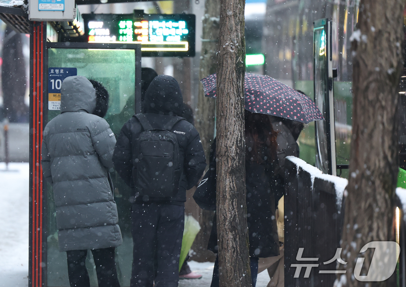 (화성=뉴스1) 김영운 기자 = 전국에 눈 또는 비가 내린 12일 오전 경기 화성시의 한 버스정류장에서 시민들이 버스를 기다리고 있다. 2025.2.12/뉴스1