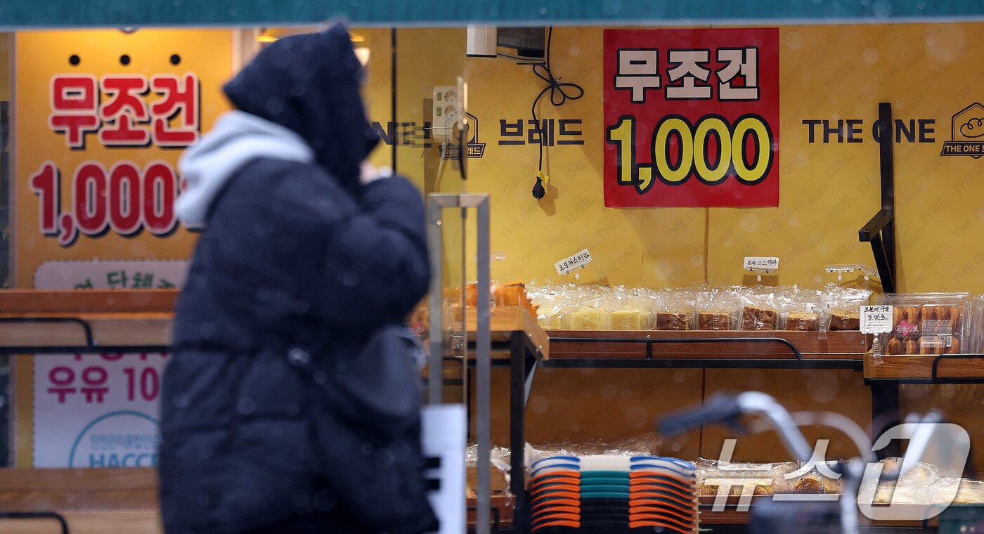 본문 이미지 - 서울의 한 1000원 빵집 앞으로 시민들이 지나가고 있다. 고물가 상황이 이어지면서 최저가 상품에만 소비자들의 관심이 쏠리는 불황형 소비패턴이 한층 확산하고 있다. 2025.2.12/뉴스1 ⓒ News1 박지혜 기자