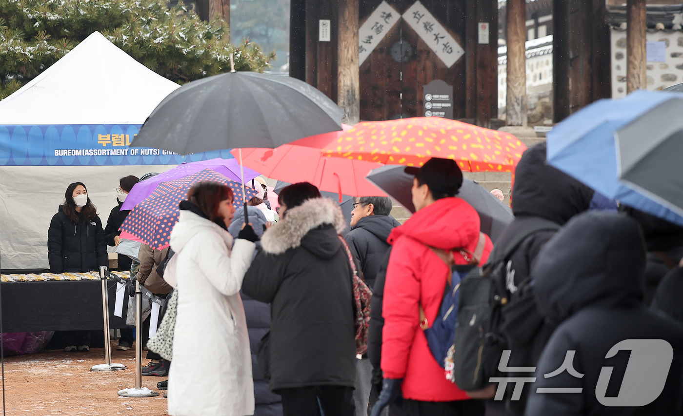 (서울=뉴스1) 김진환 기자 = 12일 오후 서울 중구 남산골한옥마을에서 열린 정월대보름 행사를 찾은 시민들이 부럼을 받기 위해 줄을 서 있다.정월대보름은 음력으로 설날이 지나고 …