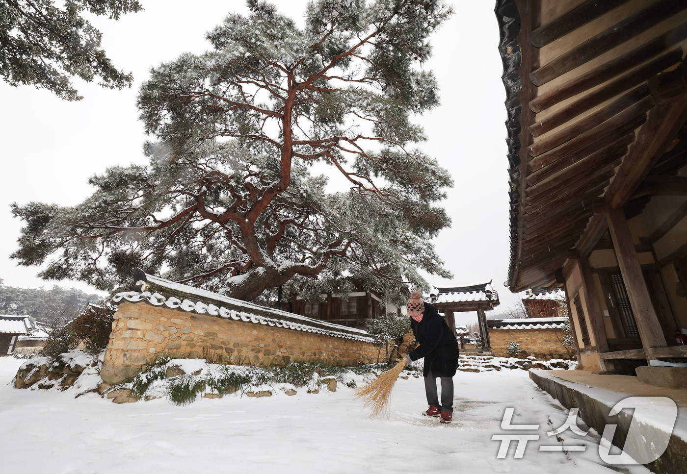 (서울=뉴스1) = 눈이 내린 12일 경남 함양군 지곡면 개평한옥마을 정여창 고택에서 관리인이 빗자루로 눈을 쓸고 있다. (함양군 김용만 제공. 재판매 및 DB 금지) 2025.2 …