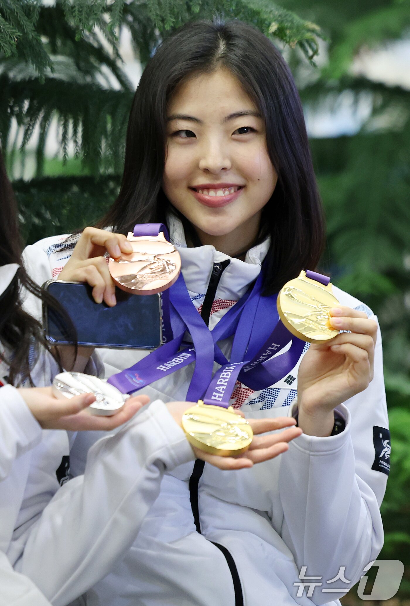 본문 이미지 - 스피드스케이팅 이나현이 제9회 하얼빈 동계아시안게임 출전을 마치고 12일 오후 인천국제공항을 통해 귀국해 메달을 들어보이고 있다. 스피드스케이팅 대표팀은 이번 대회에서 금메달 3개, 은메달 5개, 동메달 4개를 수확했다. 2025.2.12/뉴스1 ⓒ News1 이동해 기자