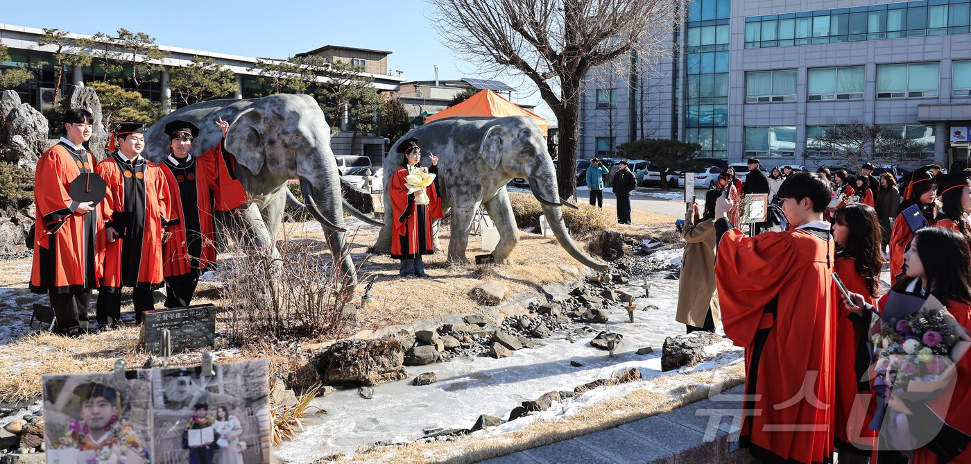 본문 이미지 - 13일 서울 중구 장충동 동국대학교에서 열린 &#39;2025년 봄 학위수여식&#39;에서 졸업생들이 코끼리 동상에 올라타 기념촬영을 하고 있다. 2025.2.13/뉴스1 ⓒ News1 김도우 기자