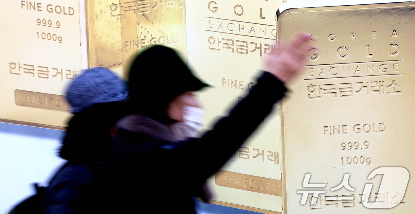 본문 이미지 - 13일 서울 종로구 한국금거래소 외벽에 부착된 골드바 사진 앞으로 시민이 지나가고 있다. 2025.2.13/뉴스1 ⓒ News1 장수영 기자