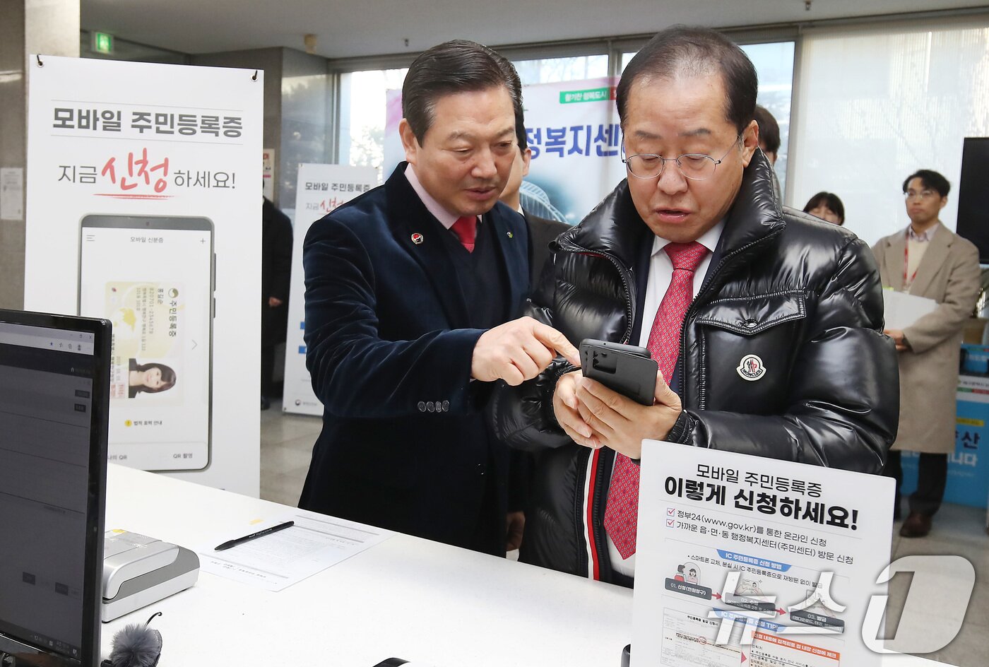 본문 이미지 - 홍준표 대구시장(오른쪽)이 14일 오전 대구 남구 봉덕2동 행정복지센터를 방문해 모바일 주민등록증을 발급받고 있다. 조재구 남구청장이 홍시장 옆에서 모바일 주민등록증 발급을 돕고 있다. 2025.2.14/뉴스1 ⓒ News1 공정식 기자