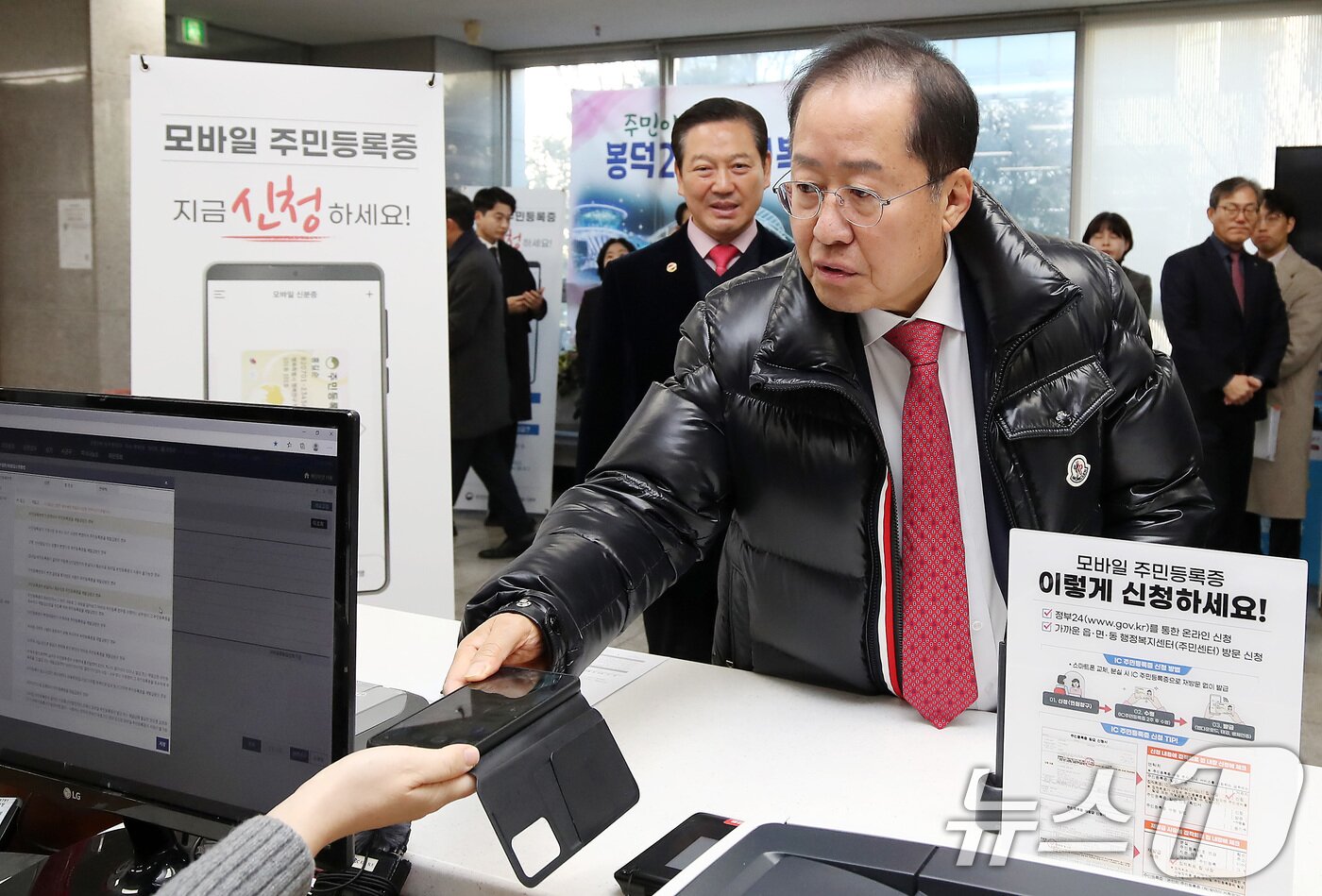 본문 이미지 - 홍준표 대구시장이 14일 오전 대구 남구 봉덕2동 행정복지센터를 방문해 모바일 주민등록증을 발급받고 있다. 2025.2.14/뉴스1 ⓒ News1 공정식 기자