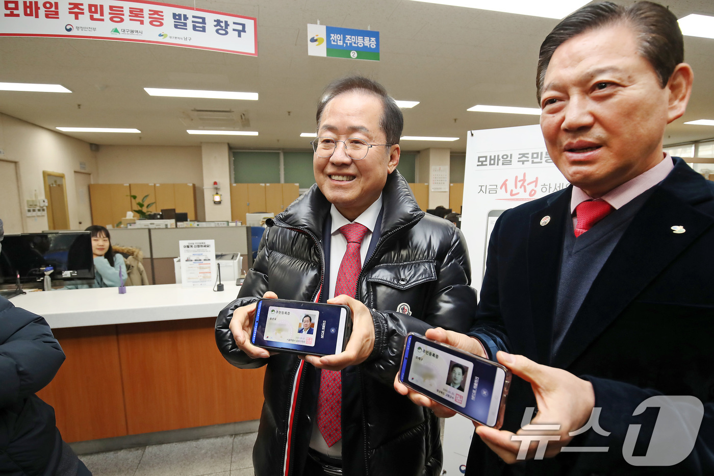 (대구=뉴스1) 공정식 기자 = 홍준표 대구시장(왼쪽)과 조재구 남구청장이 14일 오전 대구 남구 봉덕2동 행정복지센터를 방문해 모바일 주민등록증을 발급받은 뒤 취재진에게 보여주고 …