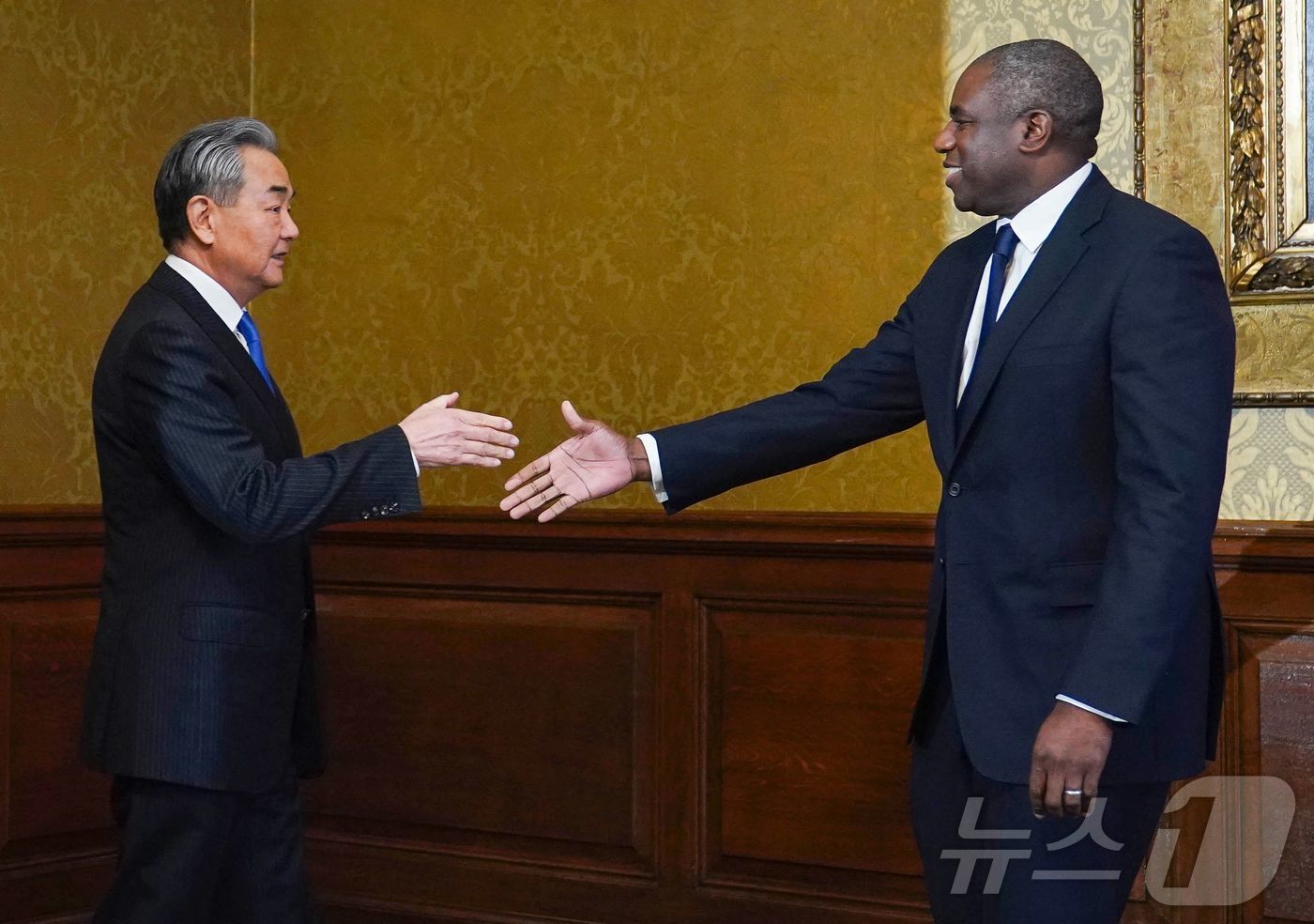 (런던 AFP=뉴스1) 우동명 기자 = 왕이 중국 외교부장이 13일(현지시간) 런던을 방문해 데이비드 래미 영국 외무장관과 만나 악수를 하고 있다. 2025.02.14ⓒ AFP=뉴 …