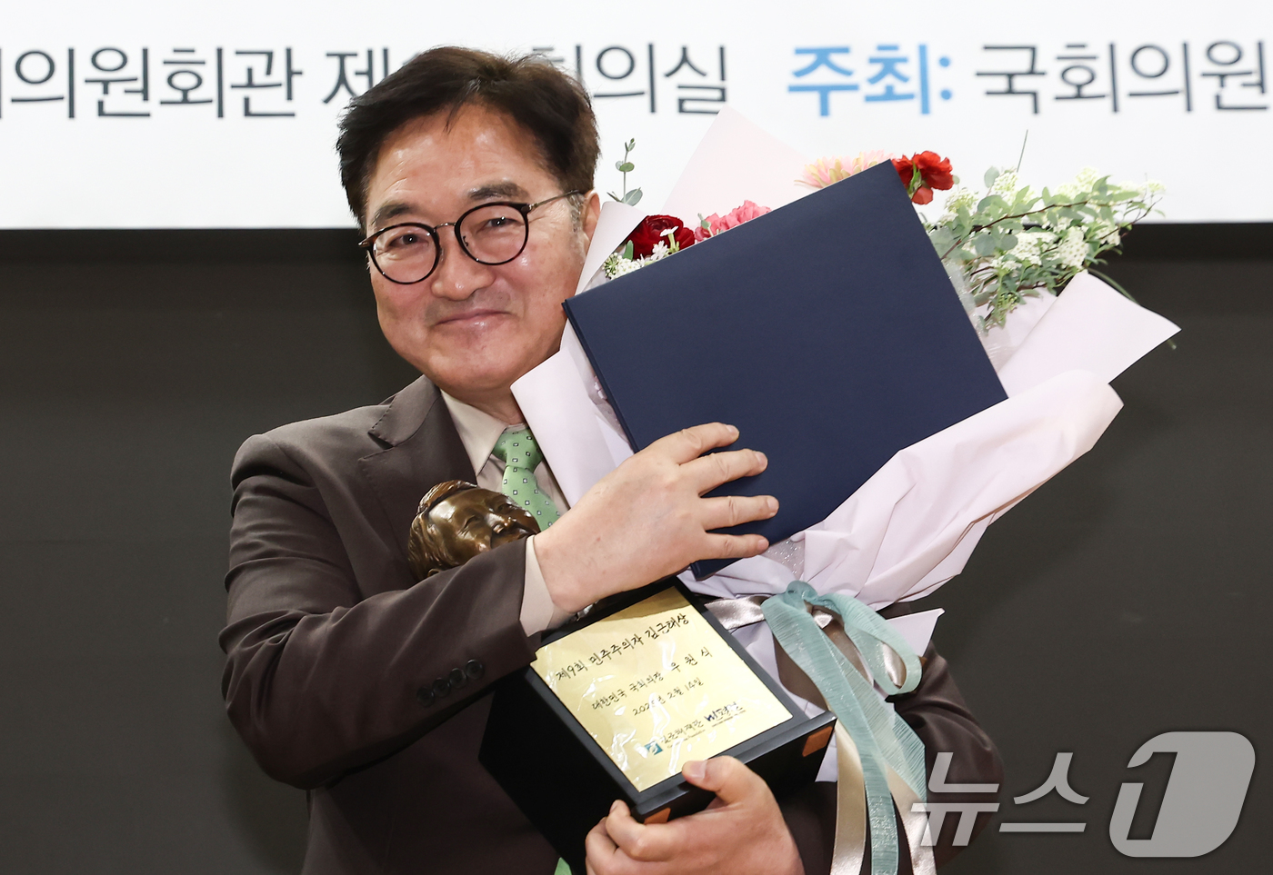 (서울=뉴스1) 김민지 기자 = 우원식 국회의장이 14일 오전 서울 여의도 국회 의원회관에서 열린 '제9회 민주주의자 김근태상 시상식'에서 김근태상 상패와 꽃다발을 들고 미소를 보 …