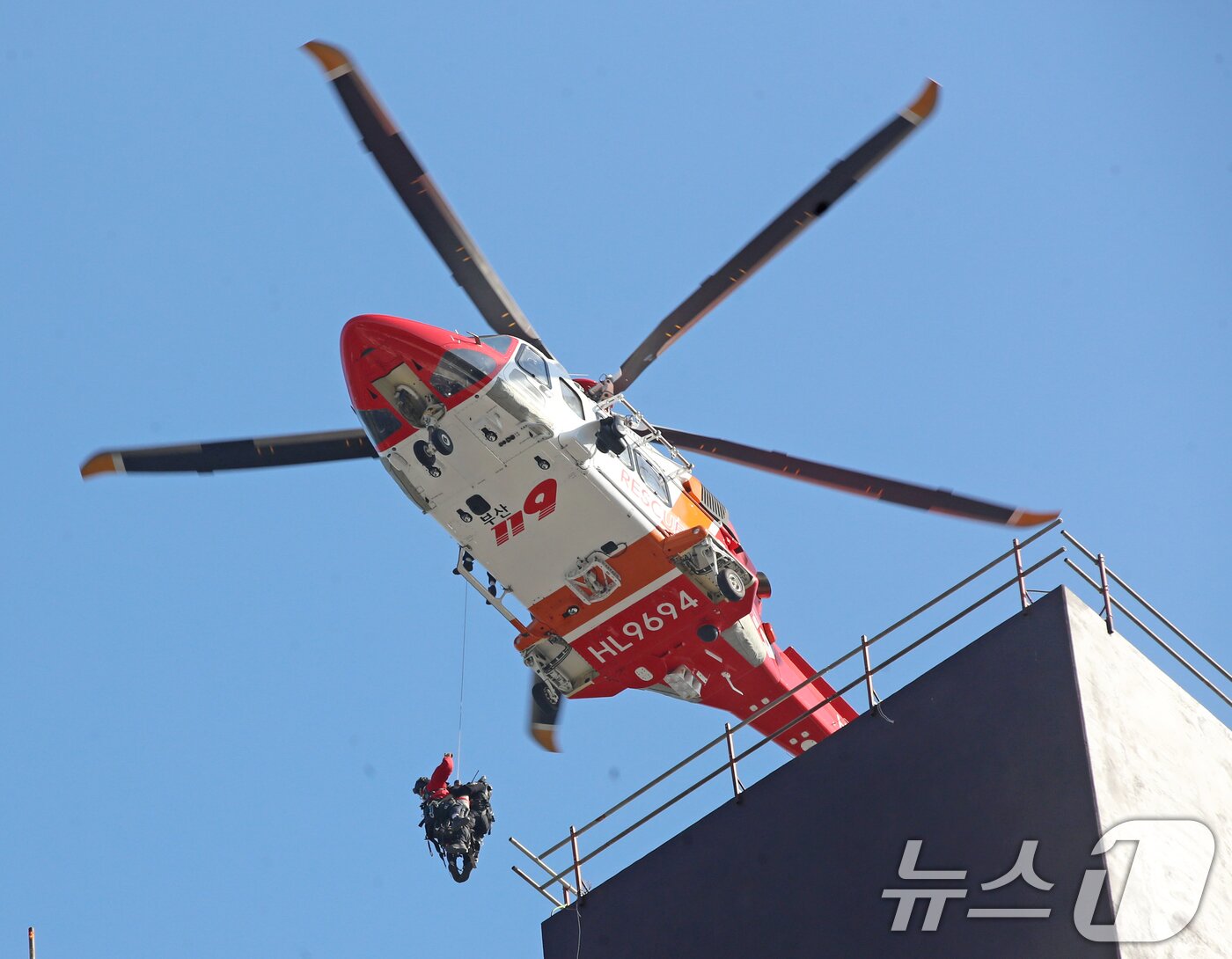 본문 이미지 - 14일 부산 기장군 반얀트리 호텔 신축 공사장에서 화재가 발생해 소방대원들이 헬기를 동원해 옥상으로 대피한 인부를 구조하고 있다. 2025.2.14/뉴스1 ⓒ News1 윤일지 기자