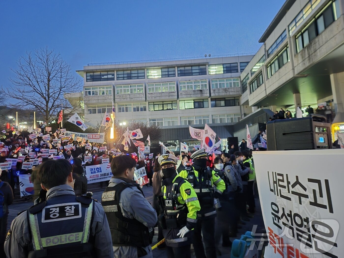 본문 이미지 - 15일 오후 7시쯤 윤석열 집회 찬반 집회 참가자들이 경찰의 '인간 폴리스라인'을 사이에 두고 대치를 이어가고 있다. ⓒ 뉴스1 남해인 기자