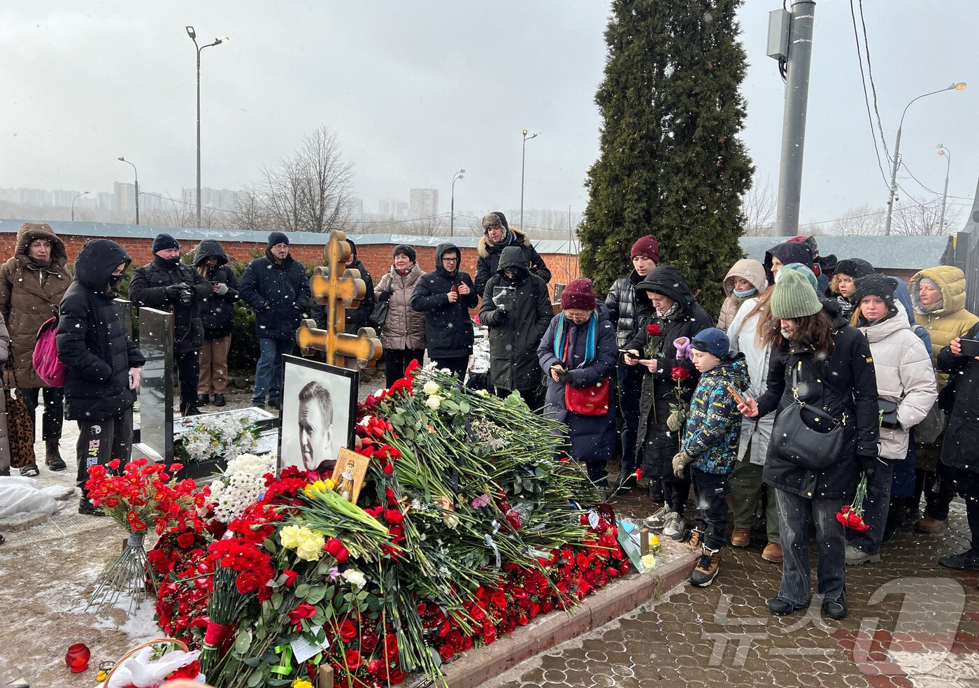 본문 이미지 - 16일(현지시간) 러시아 모스크바 보리솝스코예 묘지에 있는 알렉세이 나발니의 묘지에서 시민들이 나발니 사망1주기를 추모하고 있다.  ⓒ 로이터=뉴스1