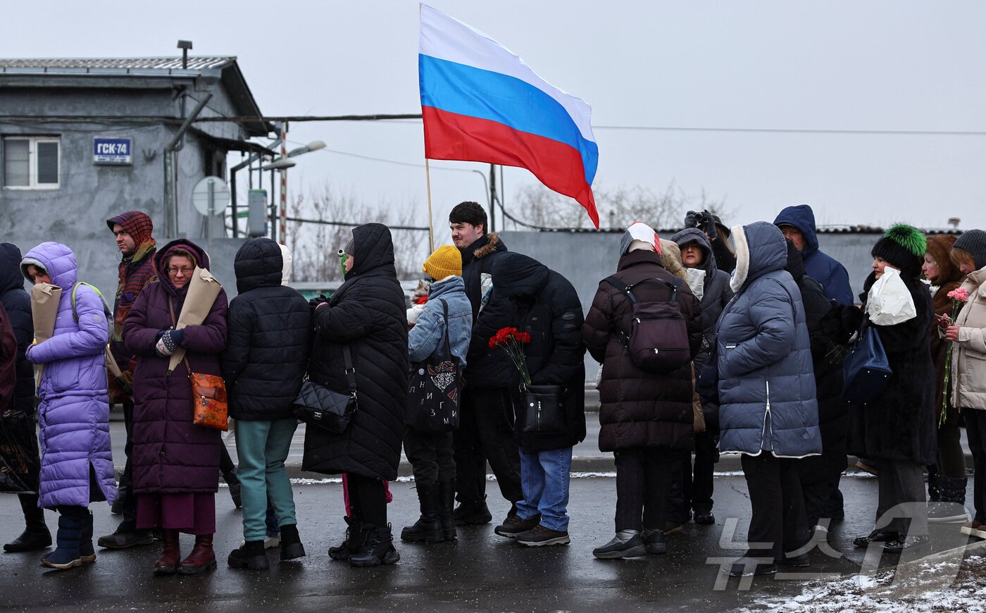 본문 이미지 - 16일(현지시간) 러시아 모스크바 보리솝스코예 묘지에 있는 알렉세이 나발니의 묘지에서 시민들이 나발니 사망1주기를 추모하고 있다.  ⓒ 로이터=뉴스1