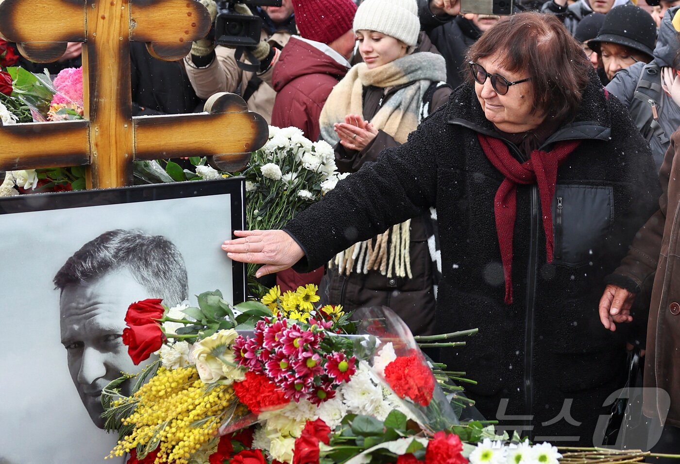 본문 이미지 - 16일(현지시간) 러시아 모스크바 보리솝스코예 묘지에 있는 알렉세이 나발니의 묘지에서 시민들이 나발니 사망1주기를 추모하고 있다. ⓒ 로이터=뉴스1