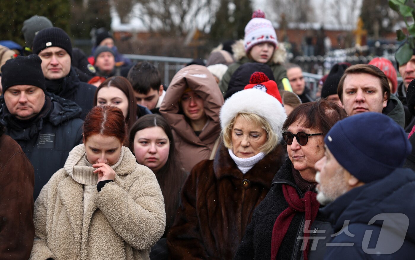 본문 이미지 - 16일(현지시간) 러시아 모스크바 보리솝스코예 묘지에 있는 알렉세이 나발니의 묘지에서 시민들이 나발니 사망1주기를 추모하고 있다.  ⓒ 로이터=뉴스1