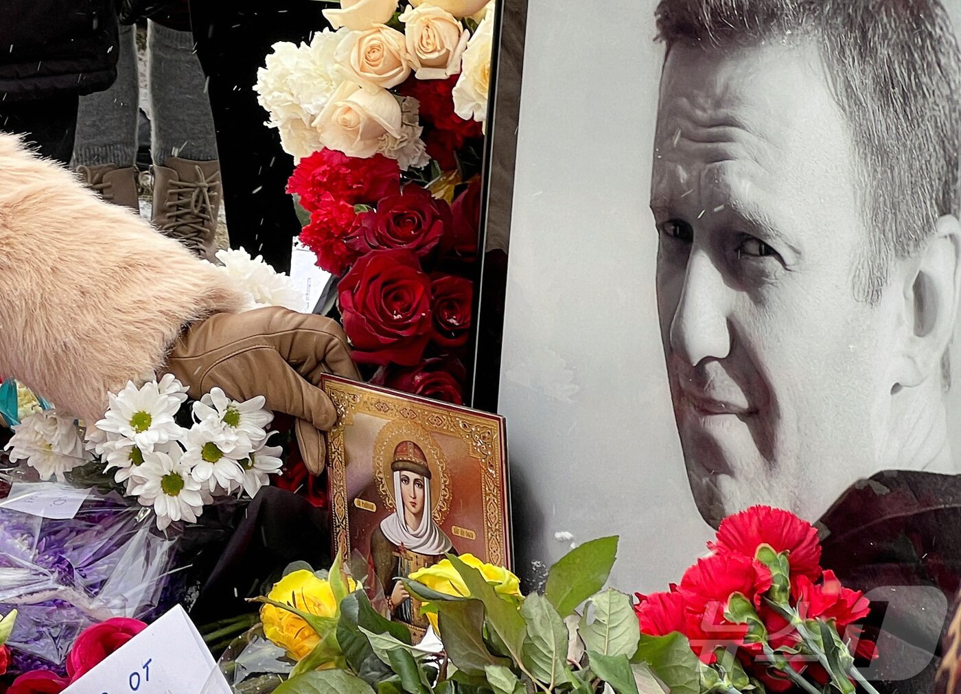 본문 이미지 - 16일(현지시간) 러시아 모스크바 보리솝스코예 묘지에 있는 알렉세이 나발니의 묘지에서 시민들이 나발니 사망1주기를 추모하고 있다. ⓒ 로이터=뉴스1