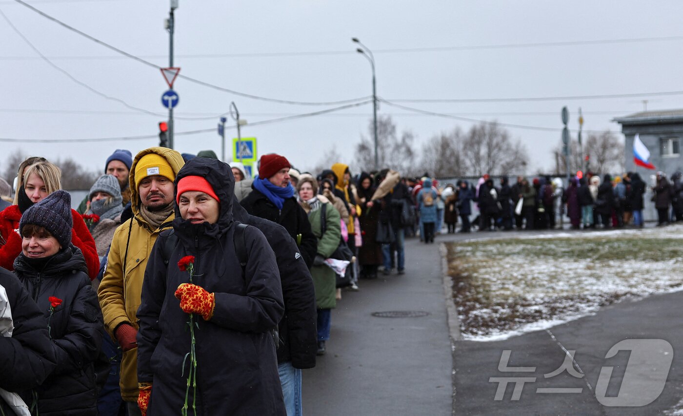 본문 이미지 - 16일(현지시간) 러시아 모스크바 보리솝스코예 묘지에 있는 알렉세이 나발니의 묘지에서 시민들이 나발니 사망1주기를 추모하고 있다. ⓒ 로이터=뉴스1