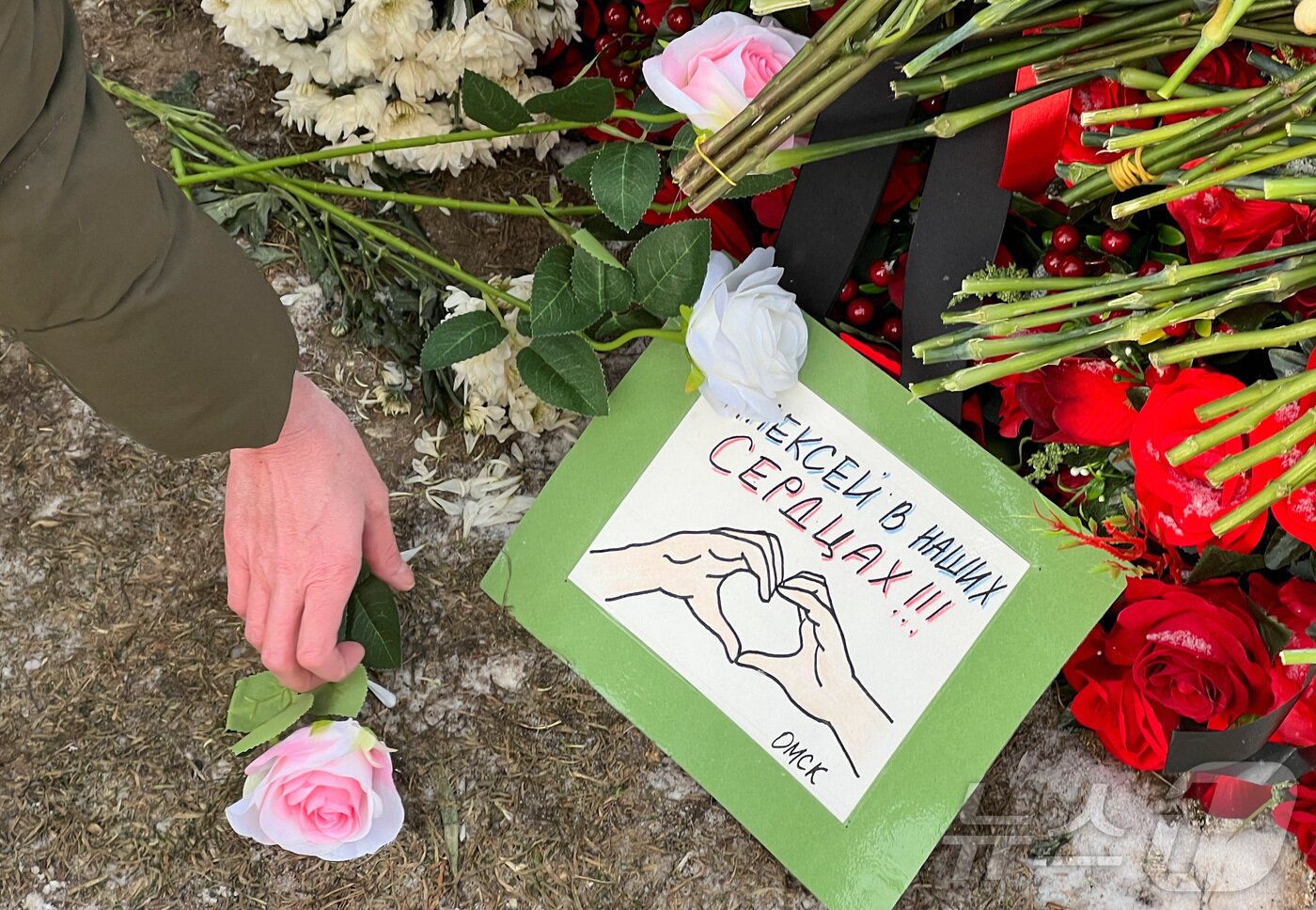 본문 이미지 - 16일(현지시간) 러시아 모스크바 보리솝스코예 묘지에 있는 알렉세이 나발니의 묘지에서 시민들이 나발니 사망1주기를 추모하고 있다. ⓒ 로이터=뉴스1