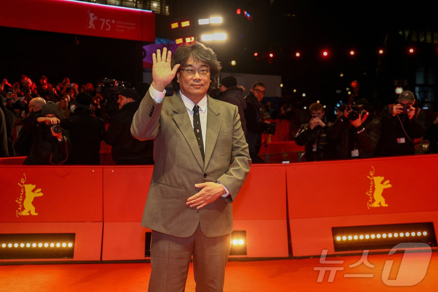본문 이미지 - 봉준호 감독이 독일 베를린에서 열린 '제75회 베를린국제영화제'에서 영화 '미키 17'상영회에 참석하며 손인사를 하고 있다. ⓒ 로이터=뉴스1