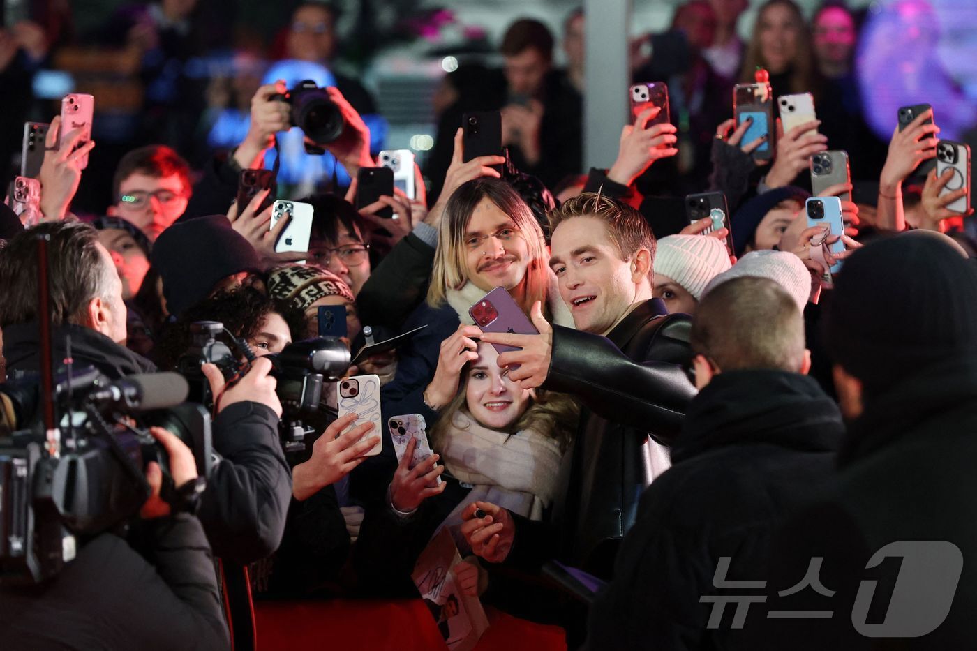 본문 이미지 - 봉준호 감독과 로버트 패틴슨이 독일 베를린에서 열린 '제75회 베를린국제영화제'에서 영화 '미키 17'상영회에 참석하며 팬들과 기념촬영을 하고 있다. ⓒ AFP=뉴스1