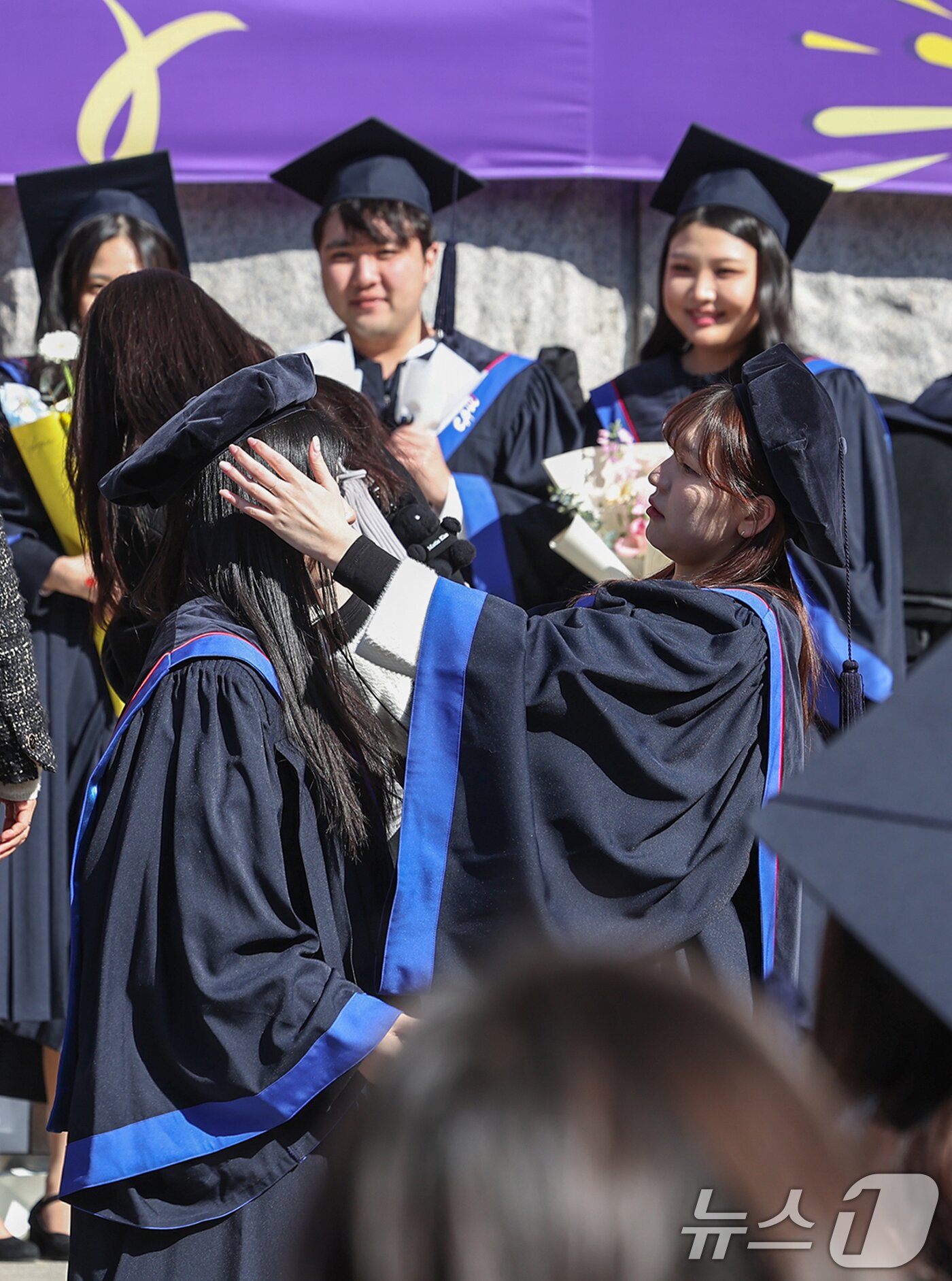 본문 이미지 - 17일 서울 동작구 중앙대학교에서 열린 &#39;2024학년도 전기 학위수여식&#39;에 참석한 한 졸업생이 친구의 학사모를 바로 씌우고 있다. 2025.2.17/뉴스1 ⓒ News1 민경석 기자
