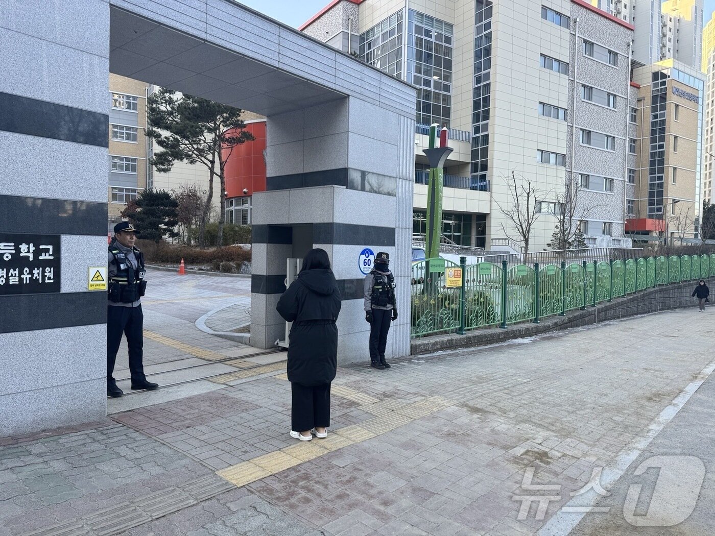 본문 이미지 - 김하늘 양 피습 사건이 일어난 대전 서구의 한 초등학교가 18일 오전 4~6학년 등교를 재개하고 있다. 한 학부모가 자녀를 등교시킨 뒤 발길을 돌리지 못하고 있다. 2025. 2. 18./뉴스1 ⓒ News1 양상인 기자