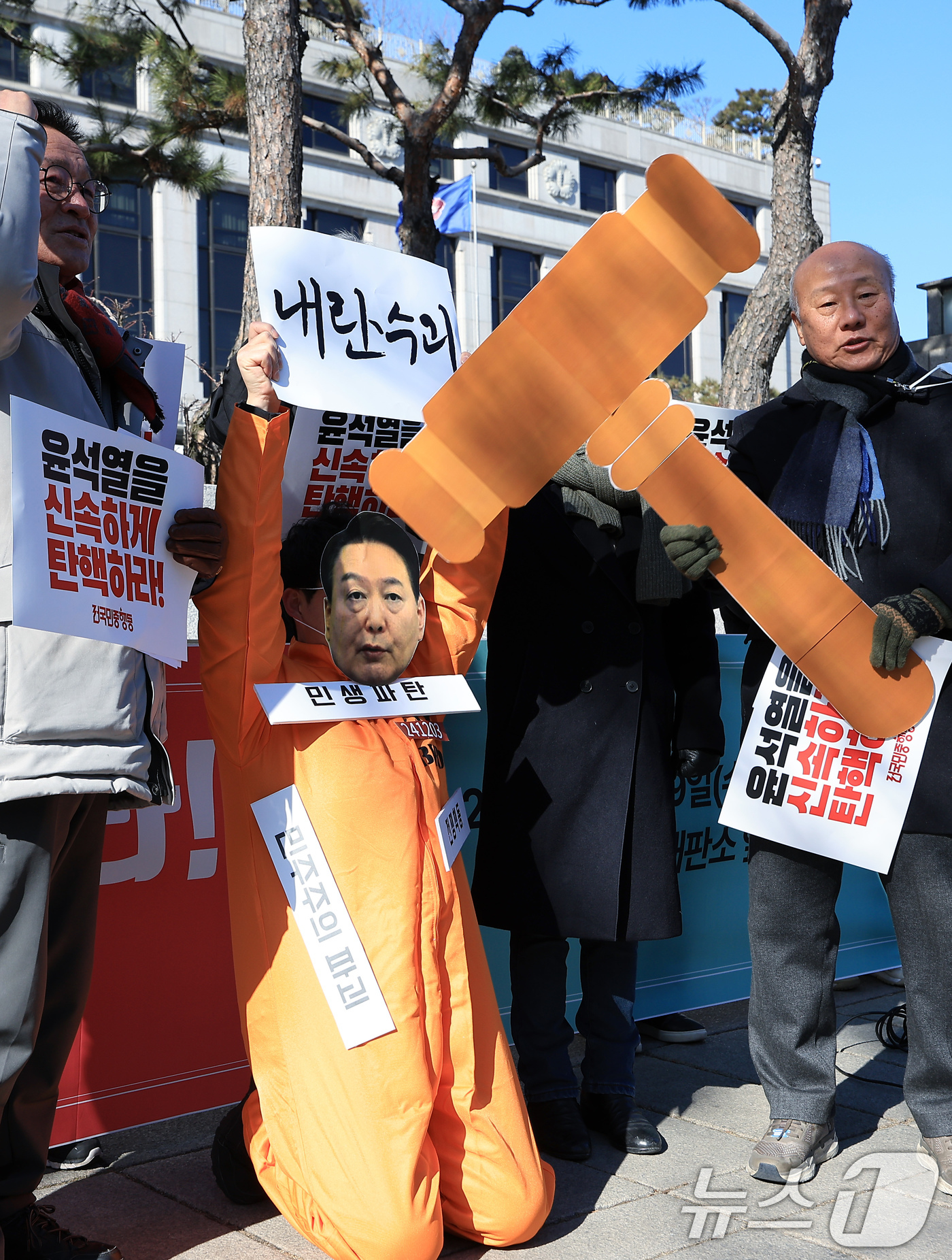 (서울=뉴스1) 박정호 기자 = 전국민중행동 박석운 공동대표와 활동가 등이 19일 오전 서울 종로구 재동 헌법재판소 앞에서 가진 윤석열 대통령 신속 파면 촉구 기자회견에서 법봉으로 …