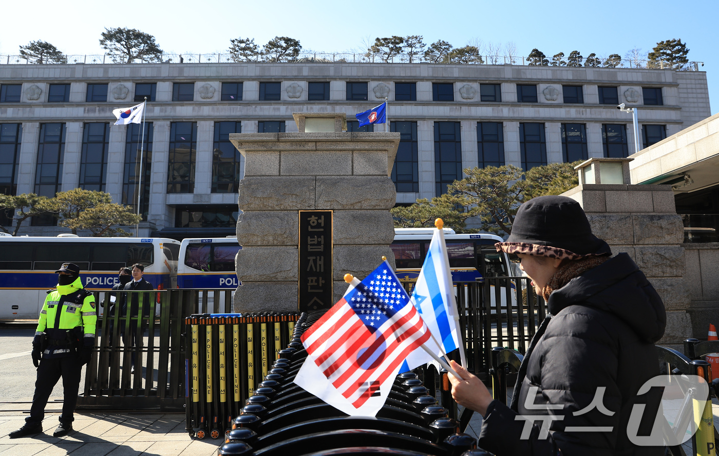 (서울=뉴스1) 박정호 기자 = 윤석열 대통령 탄핵심판 10차 변론을 하루 앞둔 19일 오후 서울 종로구 재동 헌법재판소 앞에서 태극기와 성조기, 이스라엘 국기를 든 시민이 경찰 …