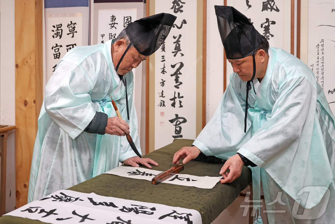 본문 이미지 - 충북 괴산 연풍향교 지명환 전교와 장홍석 사무국장이 지난 1일 24절기의 첫 절기인 입춘을 앞두고 ‘입춘대길&#40;立春大吉&#41;, 건양다경&#40;建陽多慶&#41;’ 입춘첩을 쓰고 있다.&#40;괴산군 제공&#41; 2025.2.2/뉴스1 