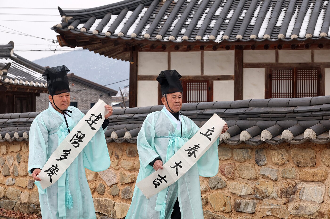 본문 이미지 - 충북 괴산 연풍향교 지명환 전교와 장홍석 사무국장이 지난 1일 24절기의 첫 절기인 입춘을 앞두고 ‘입춘대길&#40;立春大吉&#41;, 건양다경&#40;建陽多慶&#41;’이라고 적힌 입춘첩을 향교 외삼문에 붙이기 위해 걸어가고 있다.&#40;괴산군 제공&#41;/뉴스1 