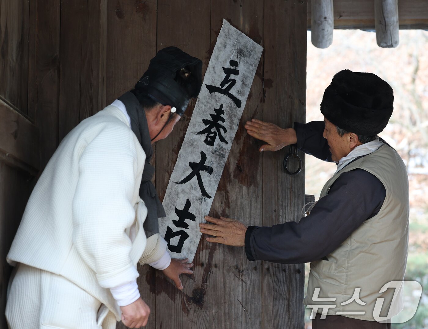 본문 이미지 - 절기상 입춘(立春)을 하루 앞둔 2일 경기 용인시 기흥구 한국민속촌에서 직원들이 새해의 복을 기원하는 마음을 담아 입춘대길(立春大吉)과 건양다경(建陽多慶)이라고 적은 입춘첩을 붙이고 있다. 2025.2.2/뉴스1 ⓒ News1 김영운 기자