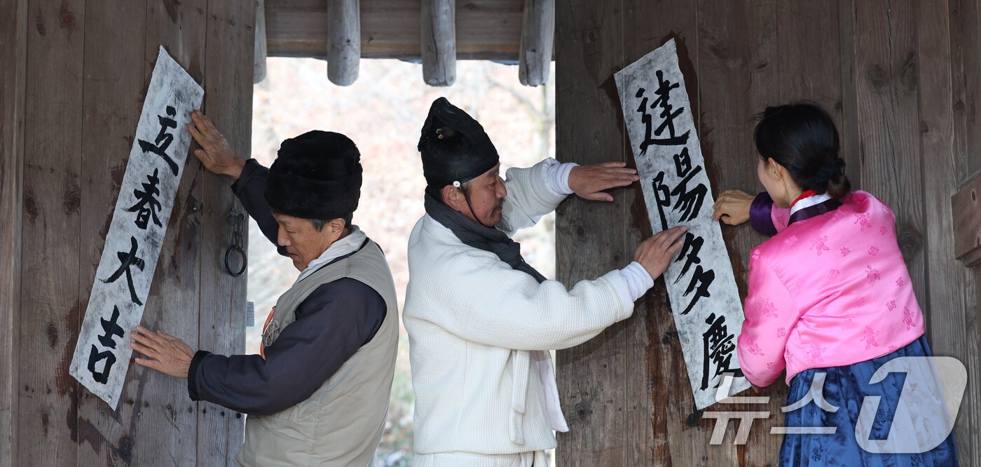 본문 이미지 - 절기상 입춘&#40;立春&#41;을 하루 앞둔 2일 경기 용인시 기흥구 한국민속촌에서 직원들이 새해의 복을 기원하는 마음을 담아 입춘대길&#40;立春大吉&#41;과 건양다경&#40;建陽多慶&#41;이라고 적은 입춘첩을 붙이고 있다. 2025.2.2/뉴스1 ⓒ News1 김영운 기자