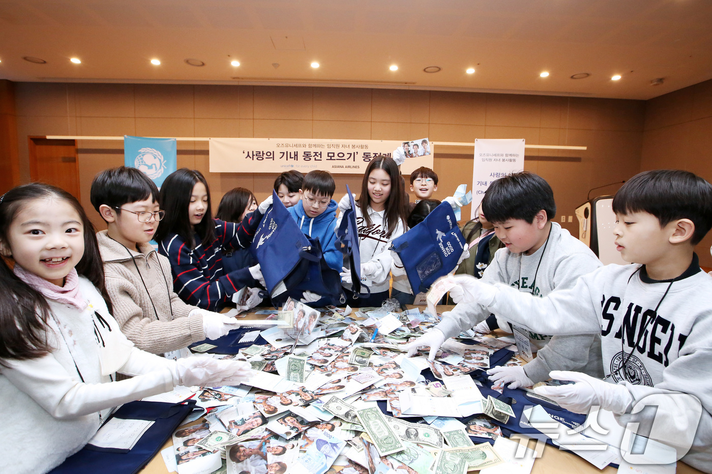 (서울=뉴스1) = 20일 서울 강서구 아시아나항공 교육훈련동에서 임직원 자녀들이 ‘사랑의 기내 동전 모으기 캠페인’으로 모인 동전을 분류하고 있다.이번 활동을 통해 분류된 동전들 …