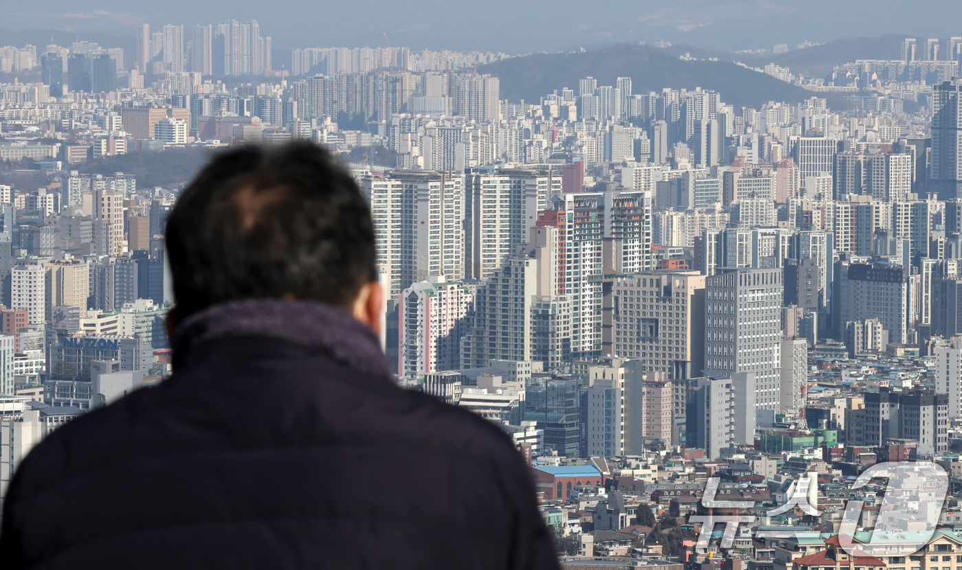 (서울=뉴스1) 장수영 기자 = 21일 오후 서울 남산을 찾은 관광객이 아파트 단지를 바라보고 있다.부동산R114에 따르면 오는 3월 서울에서는 성북구 장위동과 광진구 자양동 대단 …