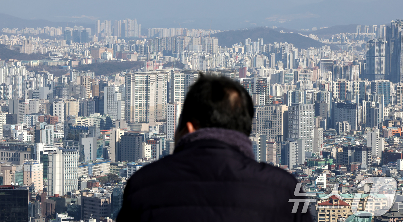 (서울=뉴스1) 장수영 기자 = 21일 오후 서울 남산을 찾은 관광객이 아파트 단지를 바라보고 있다.부동산R114에 따르면 오는 3월 서울에서는 성북구 장위동과 광진구 자양동 대단 …