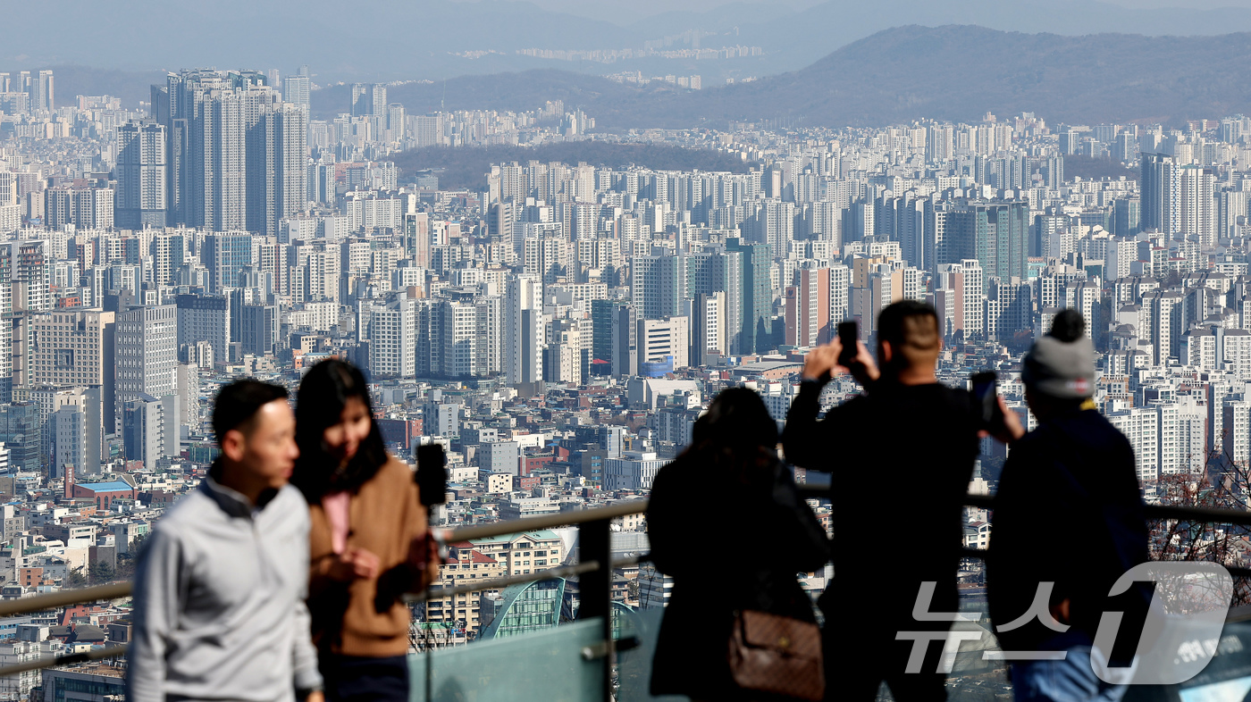 (서울=뉴스1) 장수영 기자 = 21일 오후 서울 남산을 찾은 관광객들이 아파트 단지를 바라보고 있다.부동산R114에 따르면 오는 3월 서울에서는 성북구 장위동과 광진구 자양동 대 …