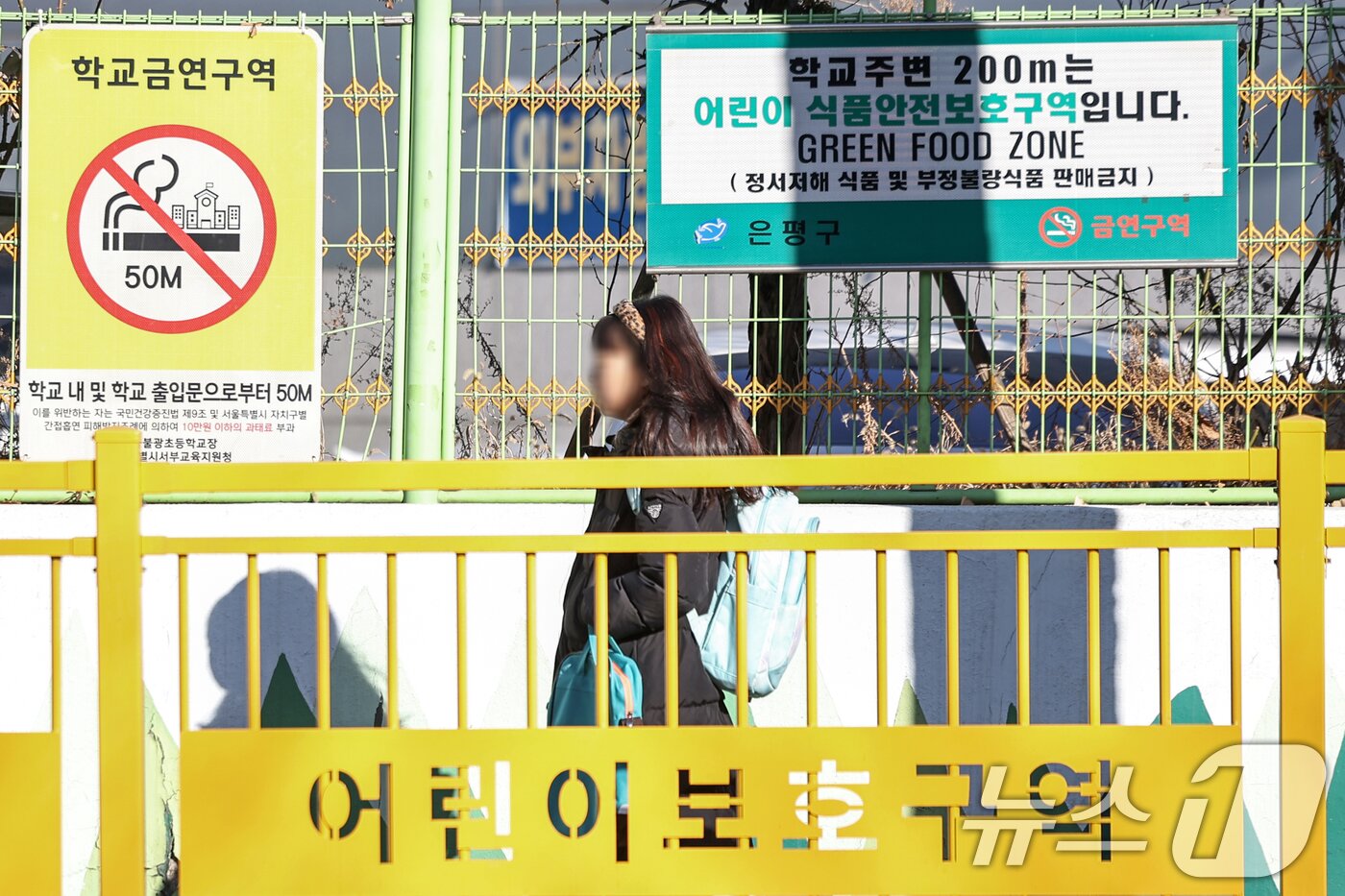 본문 이미지 - 서울의 한 초등학교에 등교하는 어린이 위로 어린이 식품안전보호구역 안내 표지판이 설치돼 있다.2025.2.24/뉴스1 ⓒ News1 민경석 기자
