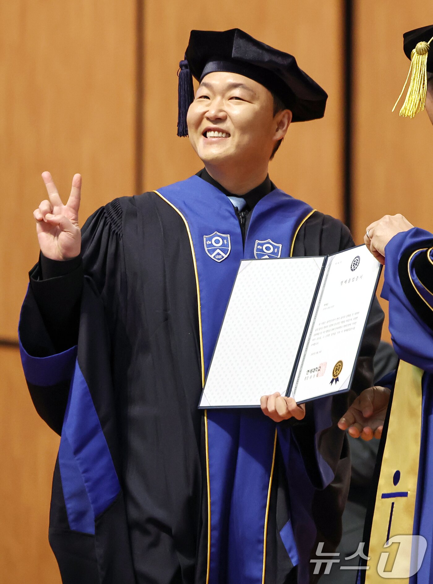 본문 이미지 - 가수 싸이(박재상)가 24일 서울 서대문구 연세대학교 대강당에서 열린 학위수여식에서 윤동섭 총장으로부터 명예졸업증서를 받으며 기뻐하고 있다. 2025.2.24/뉴스1 ⓒ News1 민경석 기자