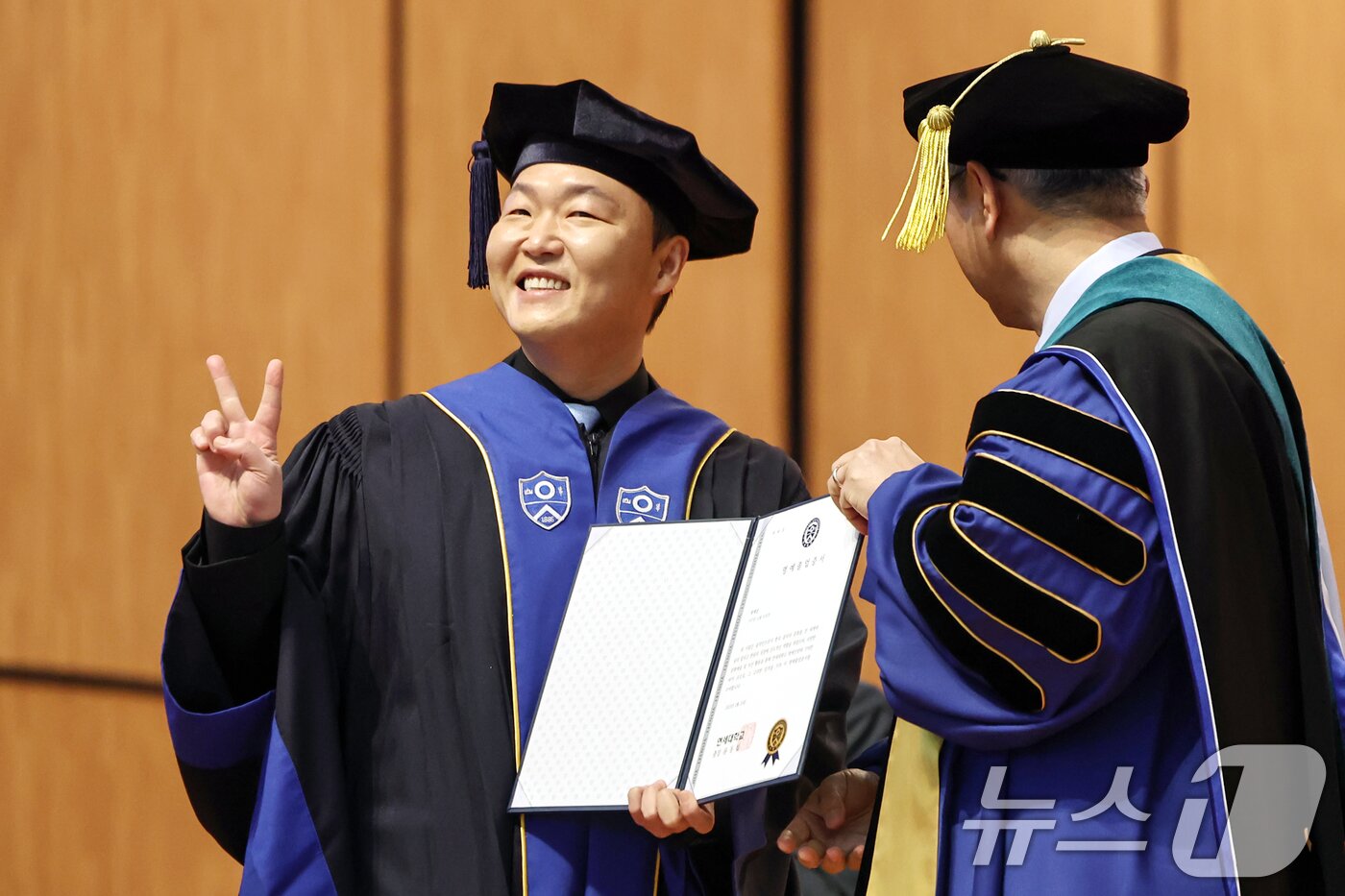 본문 이미지 - 가수 싸이(박재상)가 24일 서울 서대문구 연세대학교 대강당에서 열린 학위수여식에서 윤동섭 총장으로부터 명예졸업증서를 받으며 기뻐하고 있다. 2025.2.24/뉴스1 ⓒ News1 민경석 기자