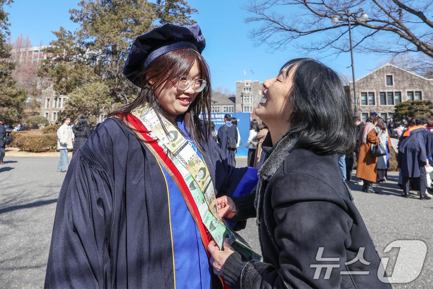 (서울=뉴스1) 민경석 기자 = 정치외교학과를 졸업하는 태국 유학생 타타(오하은)씨가 24일 서울 서대문구 연세대학교에서 열린 학위수여식에서 어머니로부터 만원권과 오만원권을 이어 …