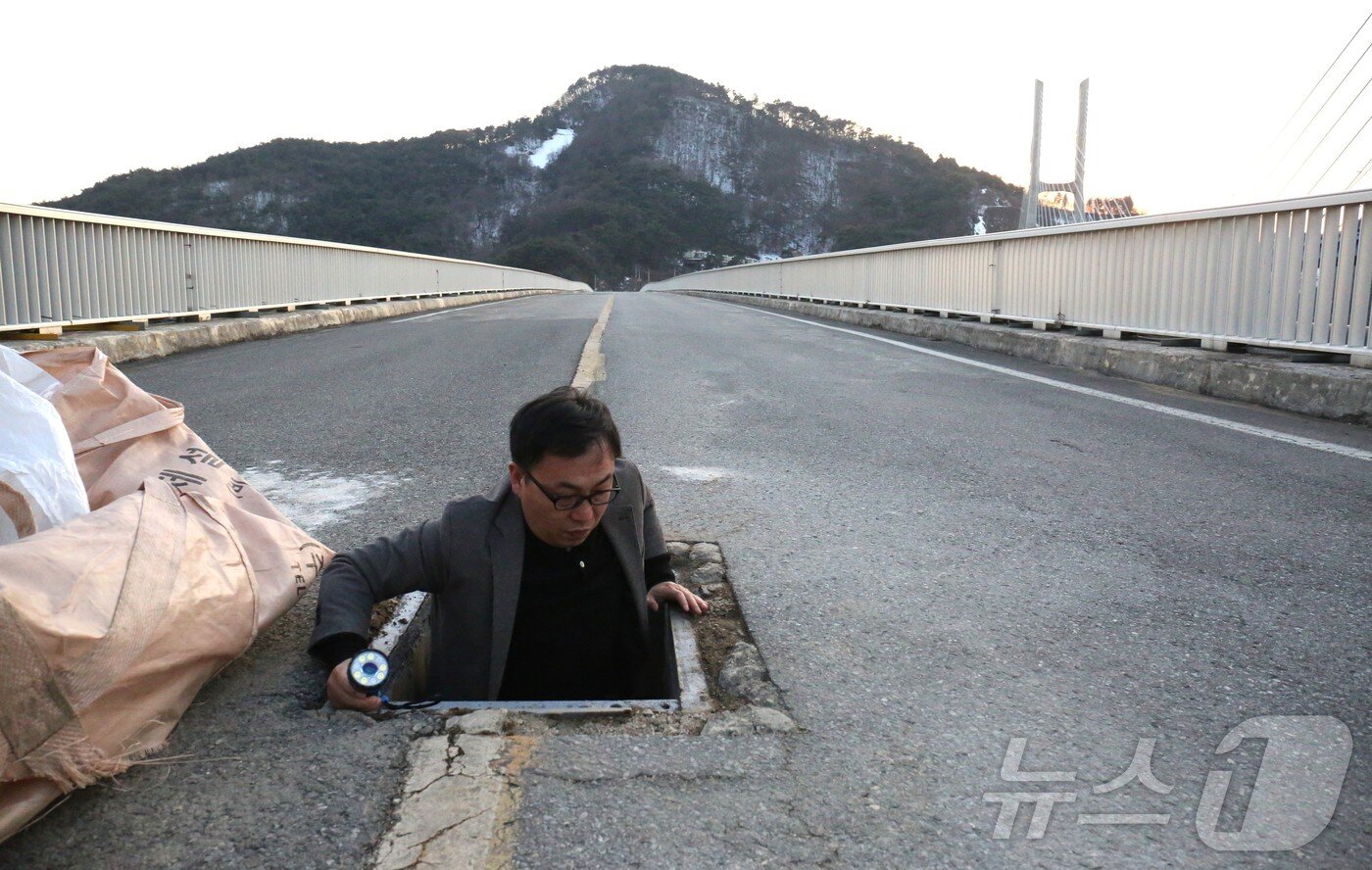 본문 이미지 - 뉴스1 취재진이 제천 옛 청풍대교 내부 비밀 공간 출입구로 진입하고 있다. 2025.2.25./뉴스1 ⓒ News1 손도언 기자 