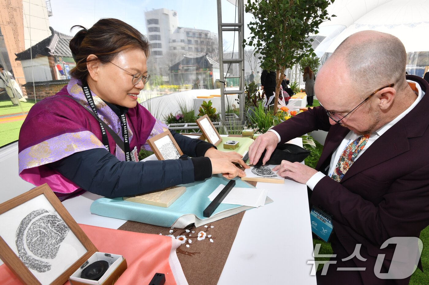 본문 이미지 - APEC 2025 KOREA (SOM1) 고위관리회의 둘째날인 25일 회의장인 경북 경주시 보문단지 경주컨벤션센터(HICO) 야외에 마련된 투명 돔 공연장에서 미국 관계자가 신라의 미소(수막새) 탁본을 직접 만들어 보고 있다. 이번 회의는 24일부터 다음 달 9일까지 HICO에서 APEC 21개 회원국 대표단 등 2000여명이 28개 회의체를 구성해 총 100여 차례의 회의를 개최한다. 2025.2.25/뉴스1 ⓒ News1 최창호 기자