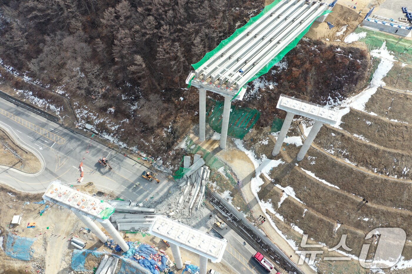 본문 이미지 - 25일 오후 경기도 안성시 서운면 서울-세종고속도로 다리 건설현장에서 교량이 붕괴된 모습이 보이고 있다. 이날 소방서에 따르면 공사 현장에서는 빔 설치를 위한 장비를 이동하다 철제 구조물이 무너지며 교각 위 설치된 가로 콘크리트 지지대가 땅 아래로 떨어졌다. 2025.2.25/뉴스1 ⓒ News1 이승배 기자